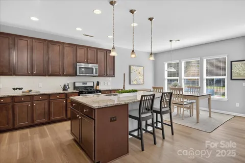 a kitchen with granite countertop wooden cabinets and stainless steel appliances