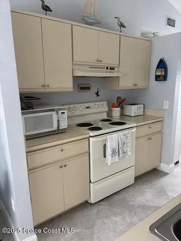 a kitchen with stainless steel appliances granite countertop white cabinets sink and stove