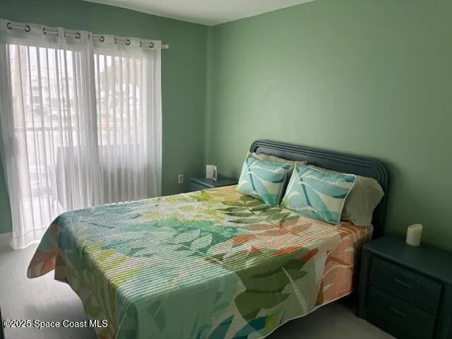 a bed sitting in a bedroom next to a window