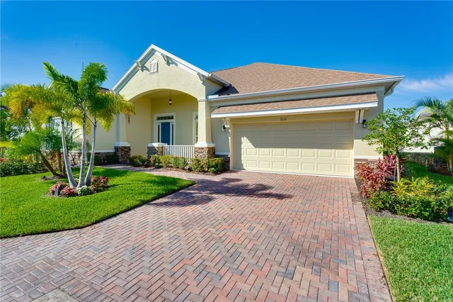 a front view of a house with a yard and potted plants
