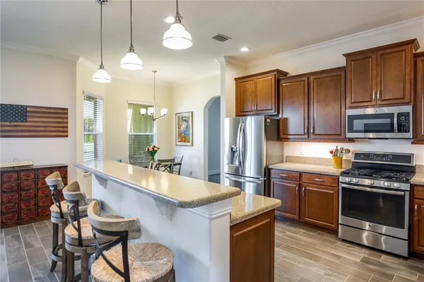 a kitchen with stainless steel appliances granite countertop a refrigerator sink and microwave