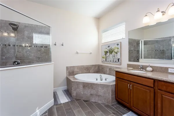 a bathroom with a tub sink and mirror