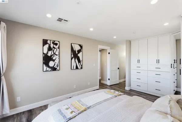 a bedroom with a large bed and painting on the wall