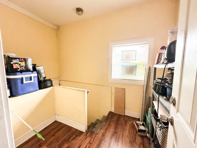 a kitchen with a refrigerator and wooden floor
