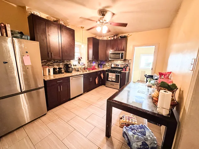 a kitchen with stainless steel appliances granite countertop a refrigerator a stove a sink dishwasher and a refrigerator