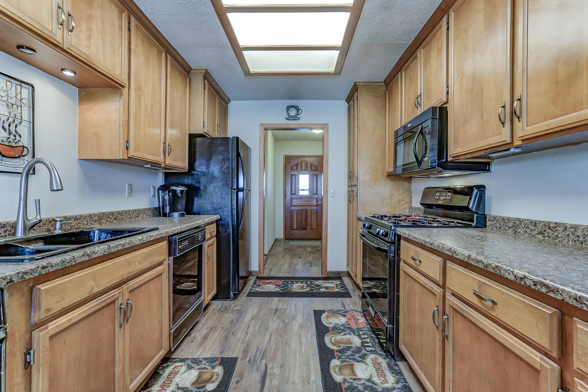2730 Hall Road Corning, CA 96021 - Photo 12 of 52 a kitchen with stainless steel appliances granite countertop a stove top oven a sink dishwasher and cabinets with wooden floor