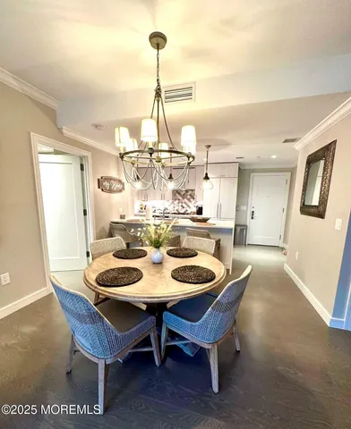 a dining room with furniture a chandelier a large window and a rug