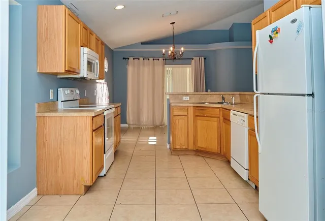 a kitchen with stainless steel appliances granite countertop a refrigerator a stove and a sink