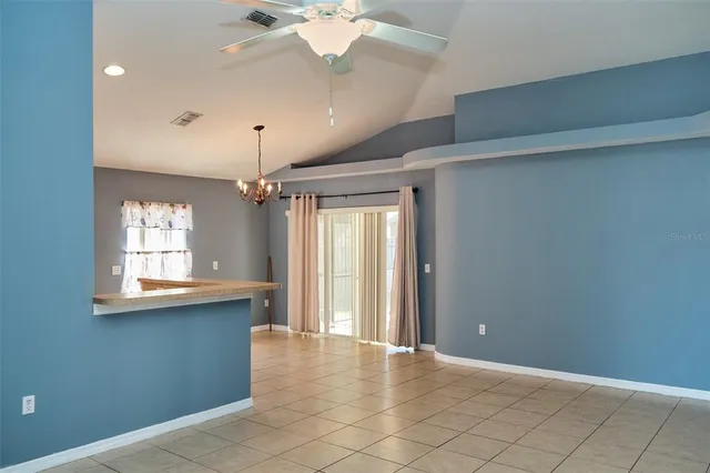 a view of a room with a chandelier fan and windows