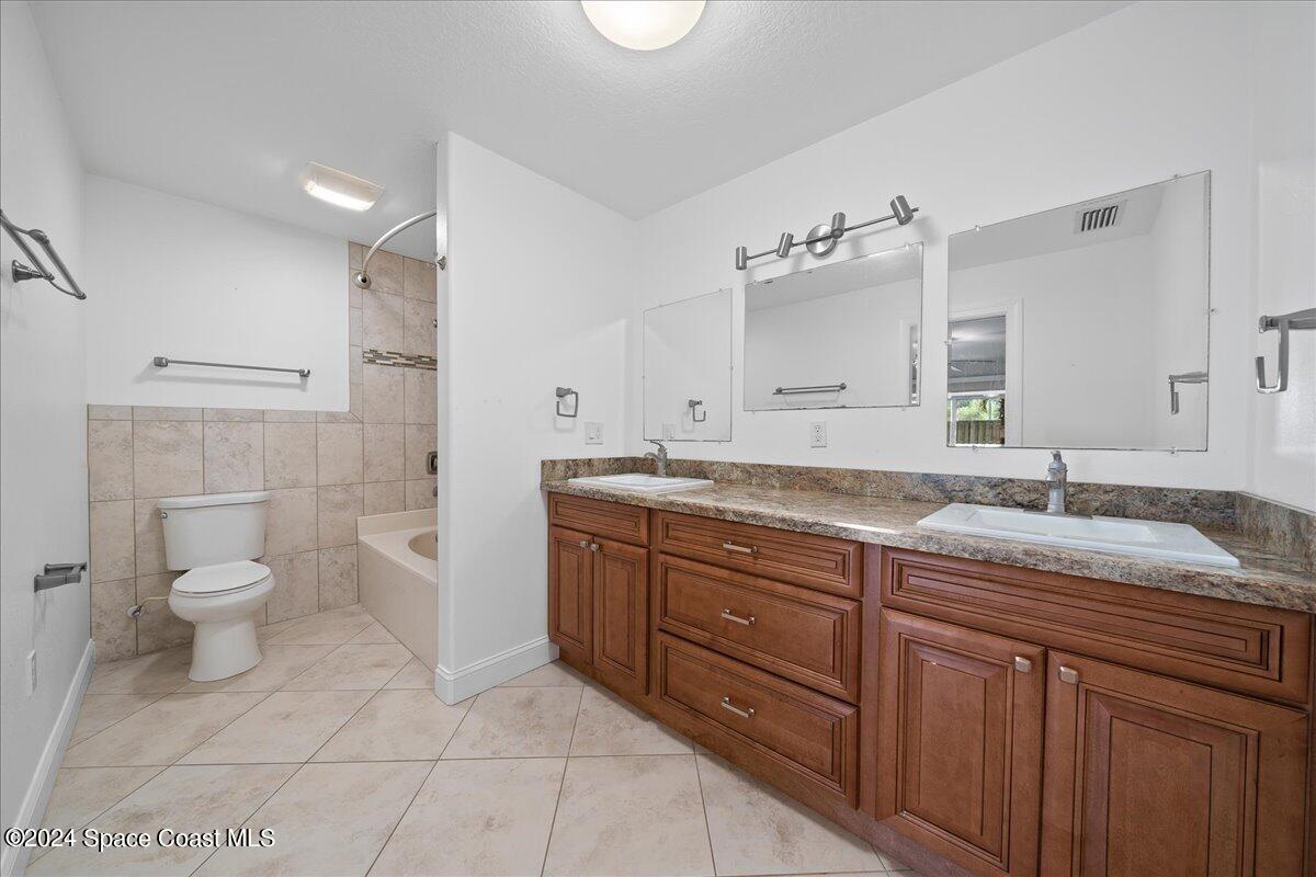 1469 Rockledge Drive Rockledge, FL 32955 - Photo 19 of 67 a bathroom with a granite countertop sink toilet and shower