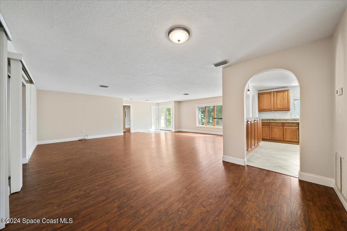 1469 Rockledge Drive Rockledge, FL 32955 - Photo 5 of 67 an empty room with wooden floor and windows
