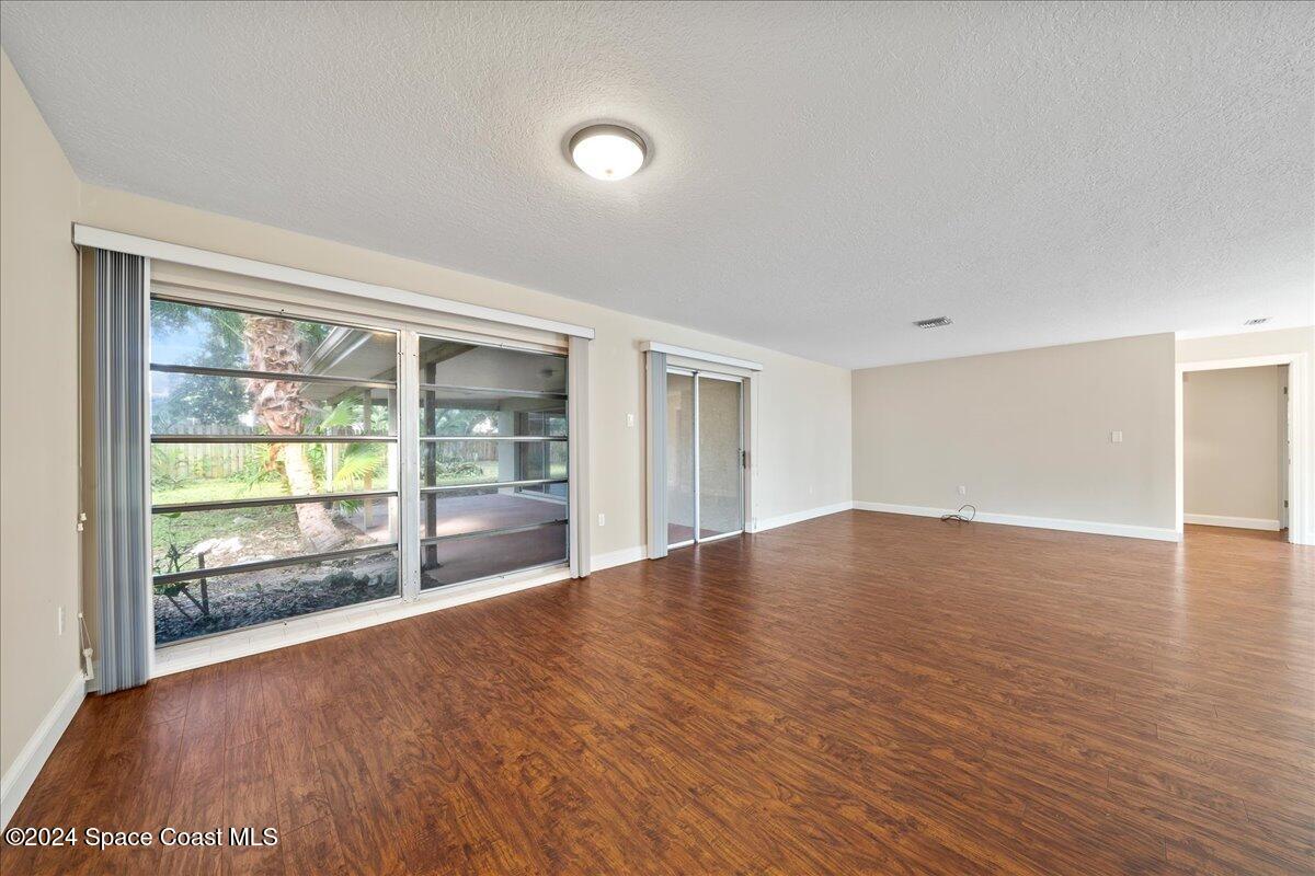 1469 Rockledge Drive Rockledge, FL 32955 - Photo 8 of 67 a view of empty room with wooden floor and fan