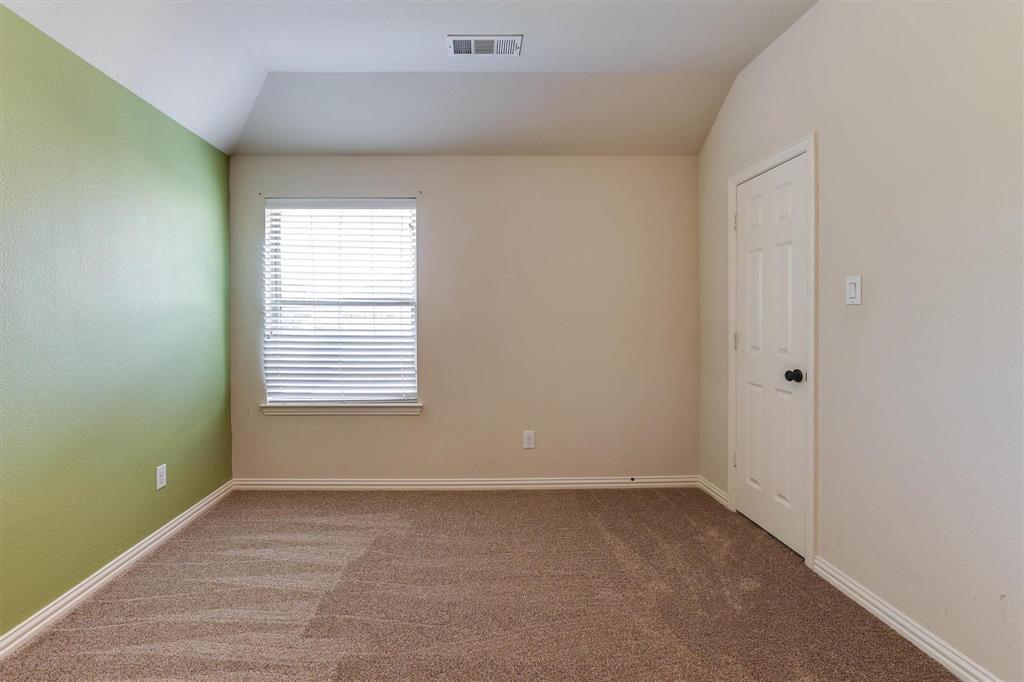 419 Rio Grande Drive Irving, TX 75039 - Photo 24 of 29 Carpeted room with a distinct green accent wall, white window blinds, and a paneled white door