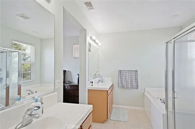 a bathroom with a bathtub a shower a sink and a window