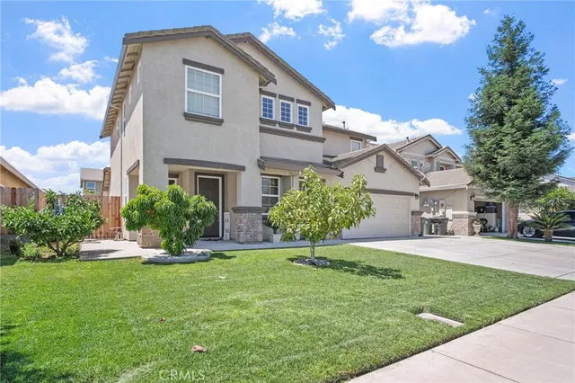 a front view of a house with a yard and trees