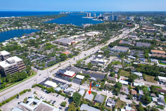 an aerial view of a city with lots of residential buildings ocean and mountain view in back