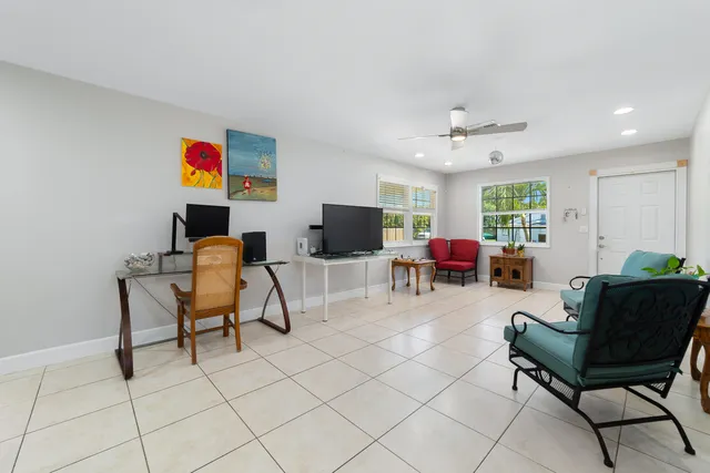 a living room with furniture a flat screen tv and kitchen view
