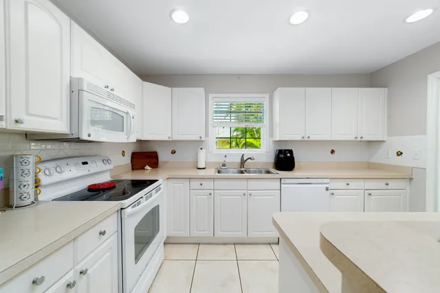 a kitchen with cabinets appliances a sink and a window