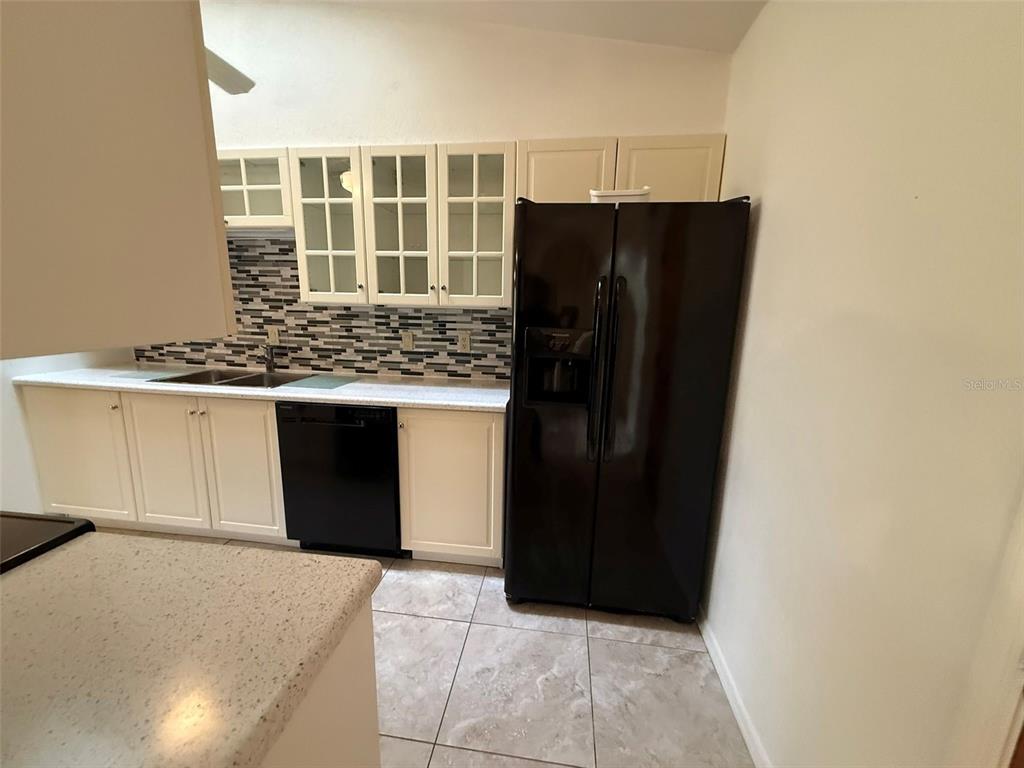 26186 Northern Cross Road, Unit 1B Punta Gorda, FL 33983 - Photo 11 of 22 a kitchen with a refrigerator and a cabinets