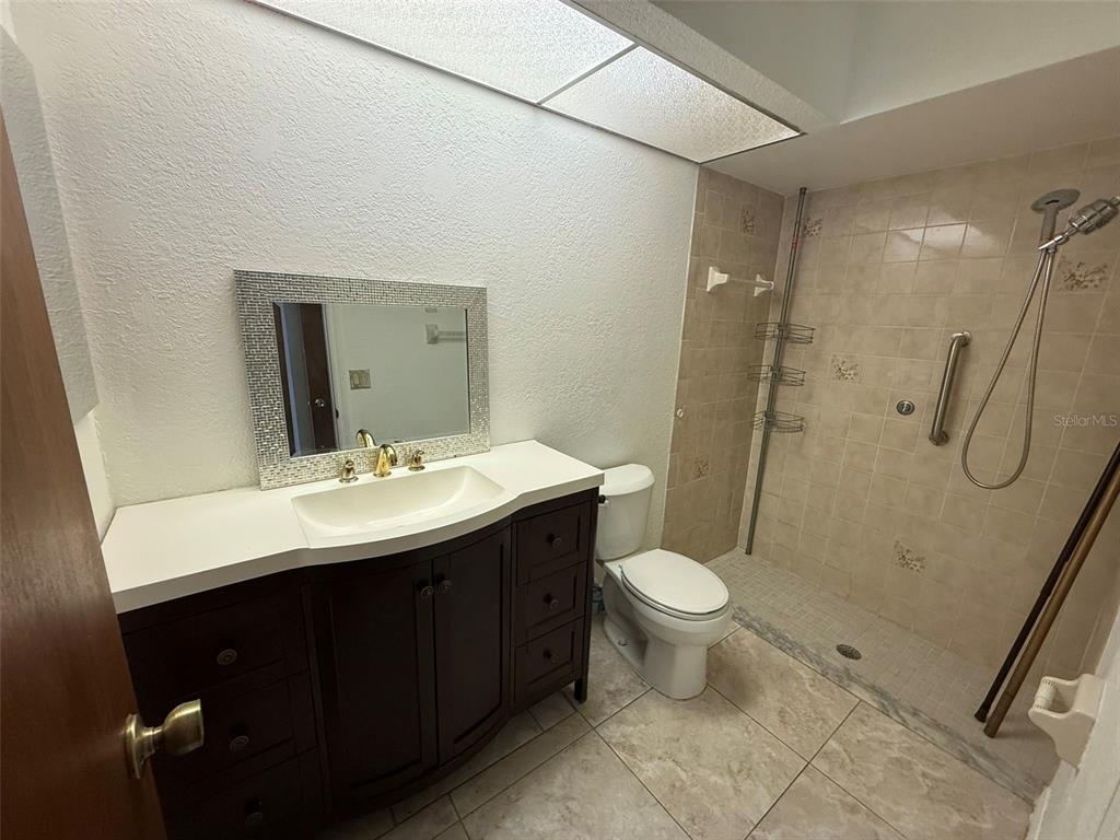 26186 Northern Cross Road, Unit 1B Punta Gorda, FL 33983 - Photo 15 of 22 a bathroom with a sink toilet and shower