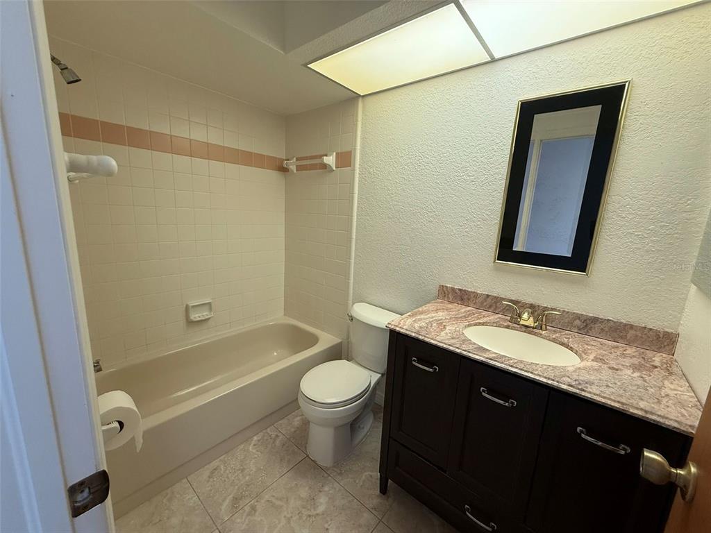 26186 Northern Cross Road, Unit 1B Punta Gorda, FL 33983 - Photo 17 of 22 a bathroom with a granite countertop sink toilet and shower