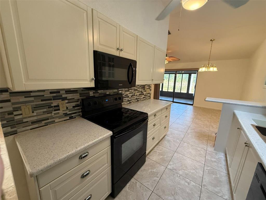 26186 Northern Cross Road, Unit 1B Punta Gorda, FL 33983 - Photo 10 of 22 a kitchen with a sink stove and microwave