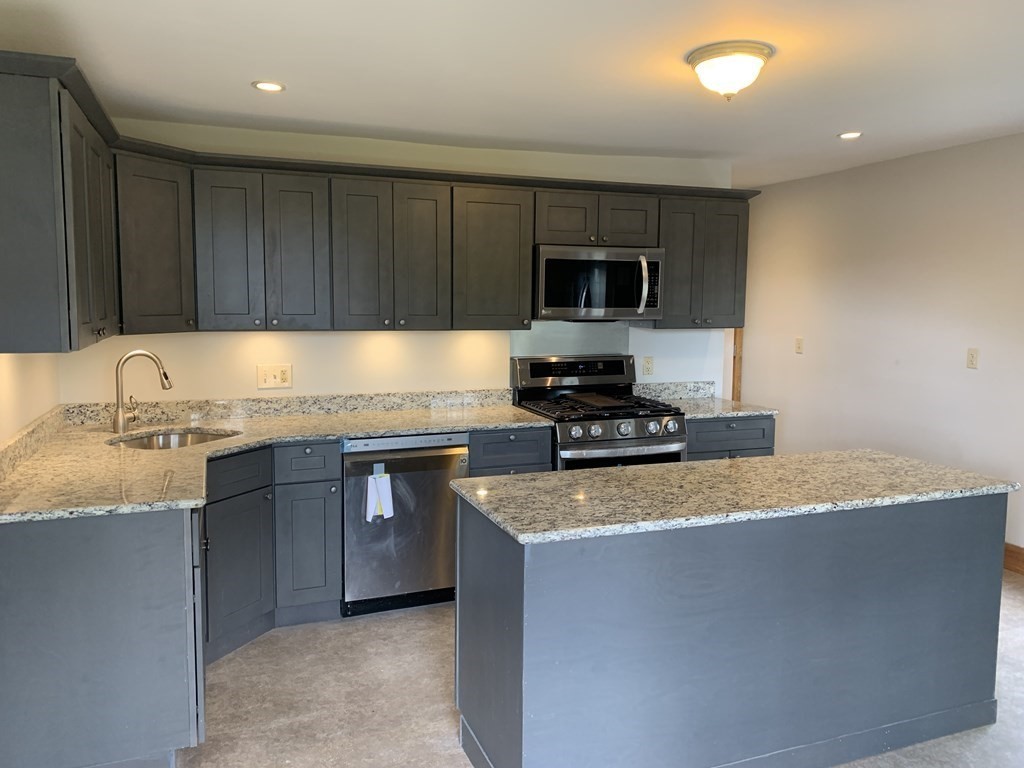 159 Chapman Street Greenfield, MA 01301 - Photo 5 of 36 a kitchen with kitchen island granite countertop a sink stainless steel appliances and cabinets