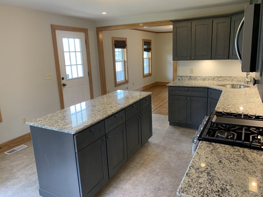 159 Chapman Street Greenfield, MA 01301 - Photo 7 of 36 a kitchen with kitchen island granite countertop a sink stove and cabinets