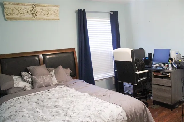 a bedroom with a bed and a flat tv screen on the dresser