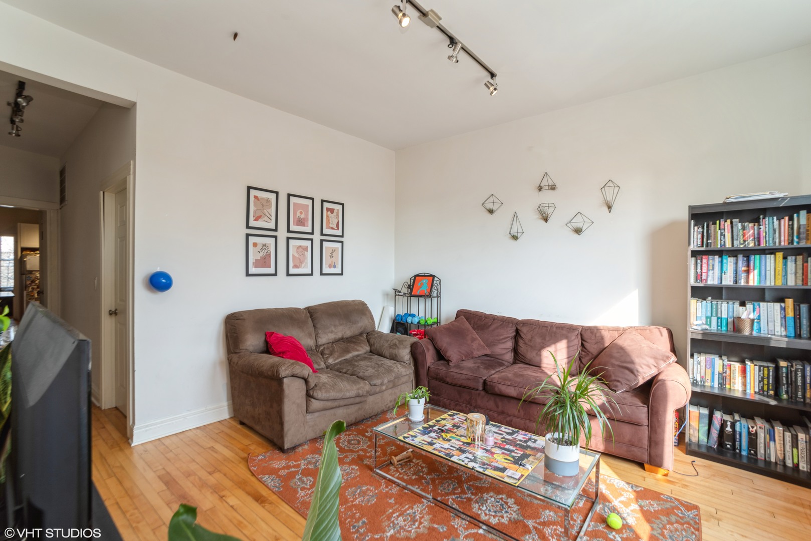 Undisclosed Address Chicago, IL 60647 - Photo 6 of 9 a living room with furniture a book shelf and a wooden floor