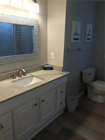 a bathroom with a granite countertop toilet sink and mirror