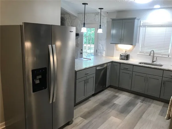 a kitchen with stainless steel appliances granite countertop a refrigerator and a sink