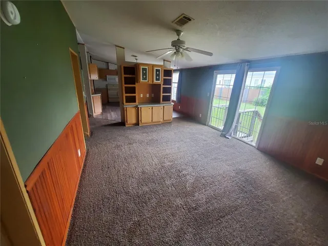 a view of an empty room with window and cabinet