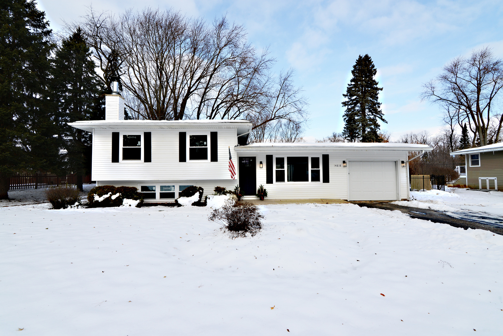 a front view of a house with a yard covered with snow