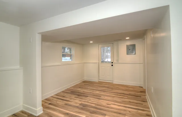 a view of a big room with wooden floor and windows