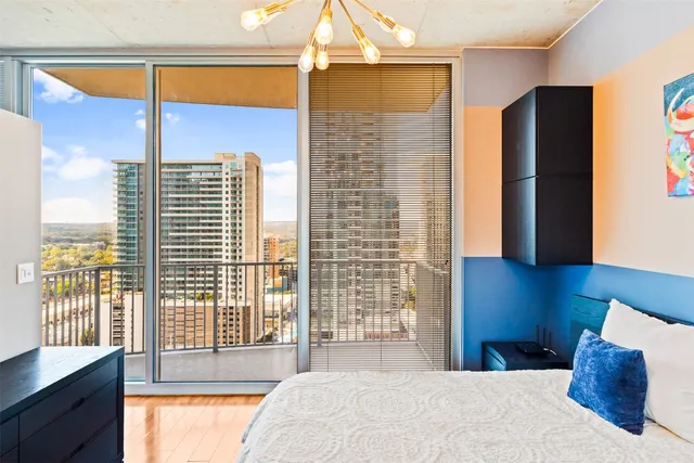 a bedroom with a large window and a bed