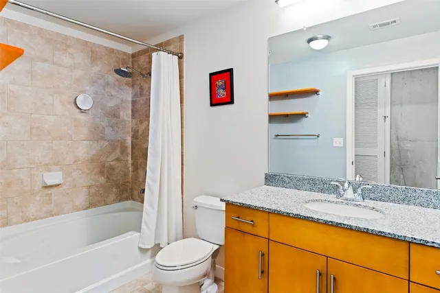 a bathroom with a granite countertop sink a toilet and shower