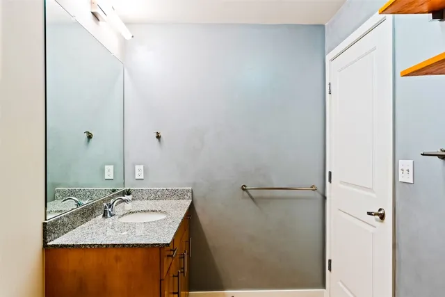 a bathroom with a granite countertop sink and a mirror