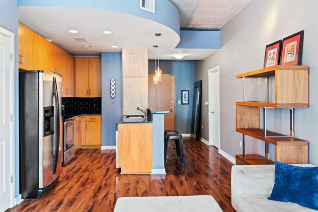 a view of living room kitchen with furniture and wooden floor