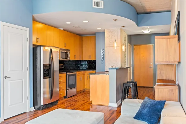 a living room with stainless steel appliances furniture and a large window
