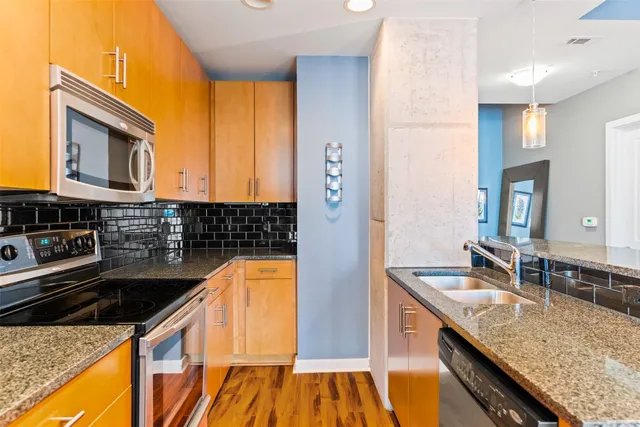 a kitchen with stainless steel appliances granite countertop a sink and cabinets