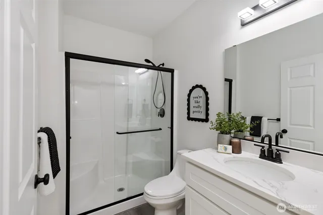 a bathroom with a granite countertop sink toilet and shower