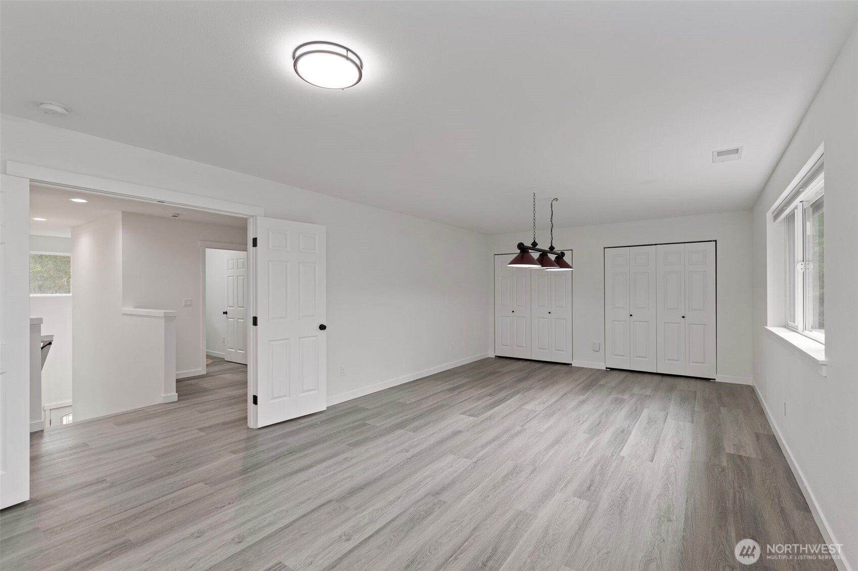 101 Northeast Anvil Lane Belfair, WA 98528 - Photo 33 of 40 an empty room with wooden floor and windows