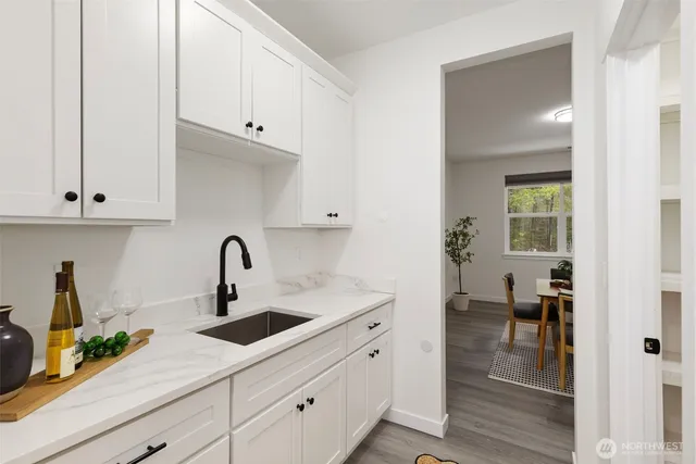 a kitchen with stainless steel appliances granite countertop white cabinets and a sink