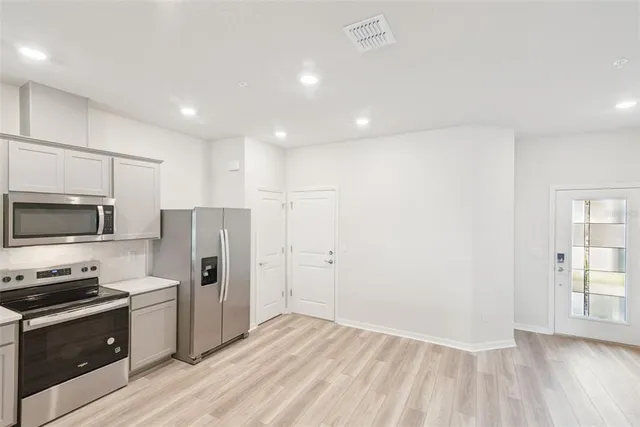 a kitchen with stainless steel appliances a refrigerator and a stove top oven