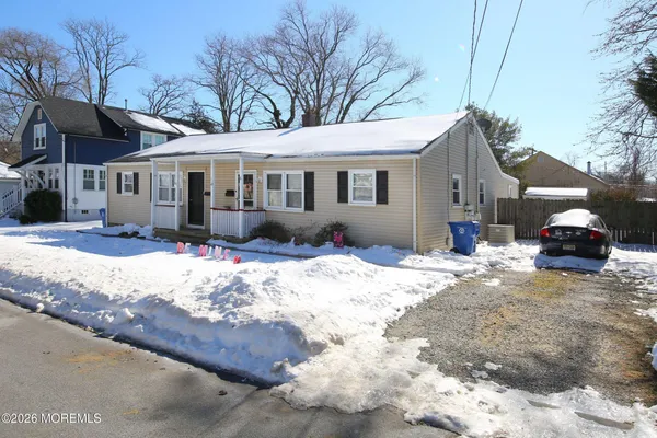 a front view of a house with a yard covered in snow