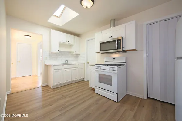 a kitchen with white cabinets and stainless steel appliances