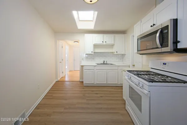 a kitchen with stainless steel appliances a stove microwave and cabinets