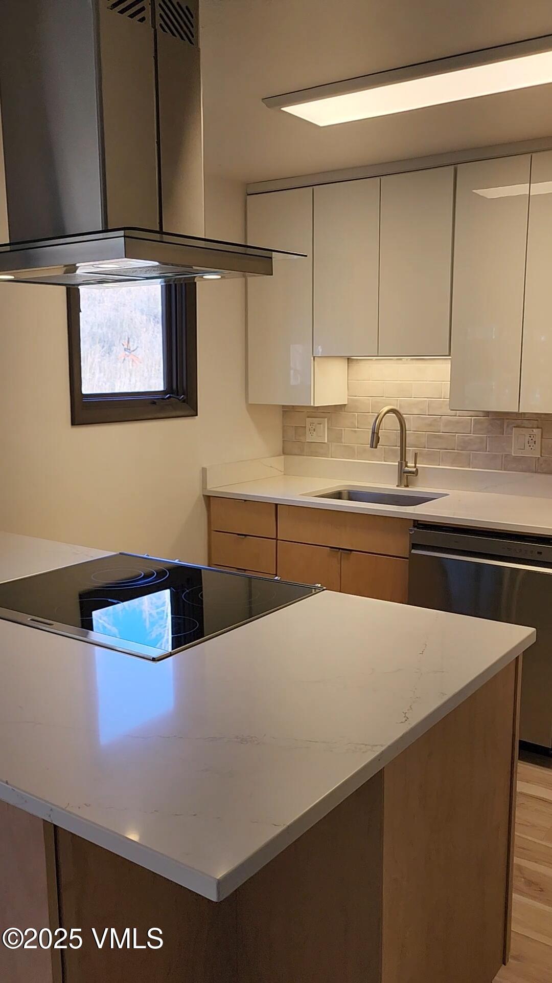 a kitchen with stainless steel appliances a sink a stove and white cabinets
