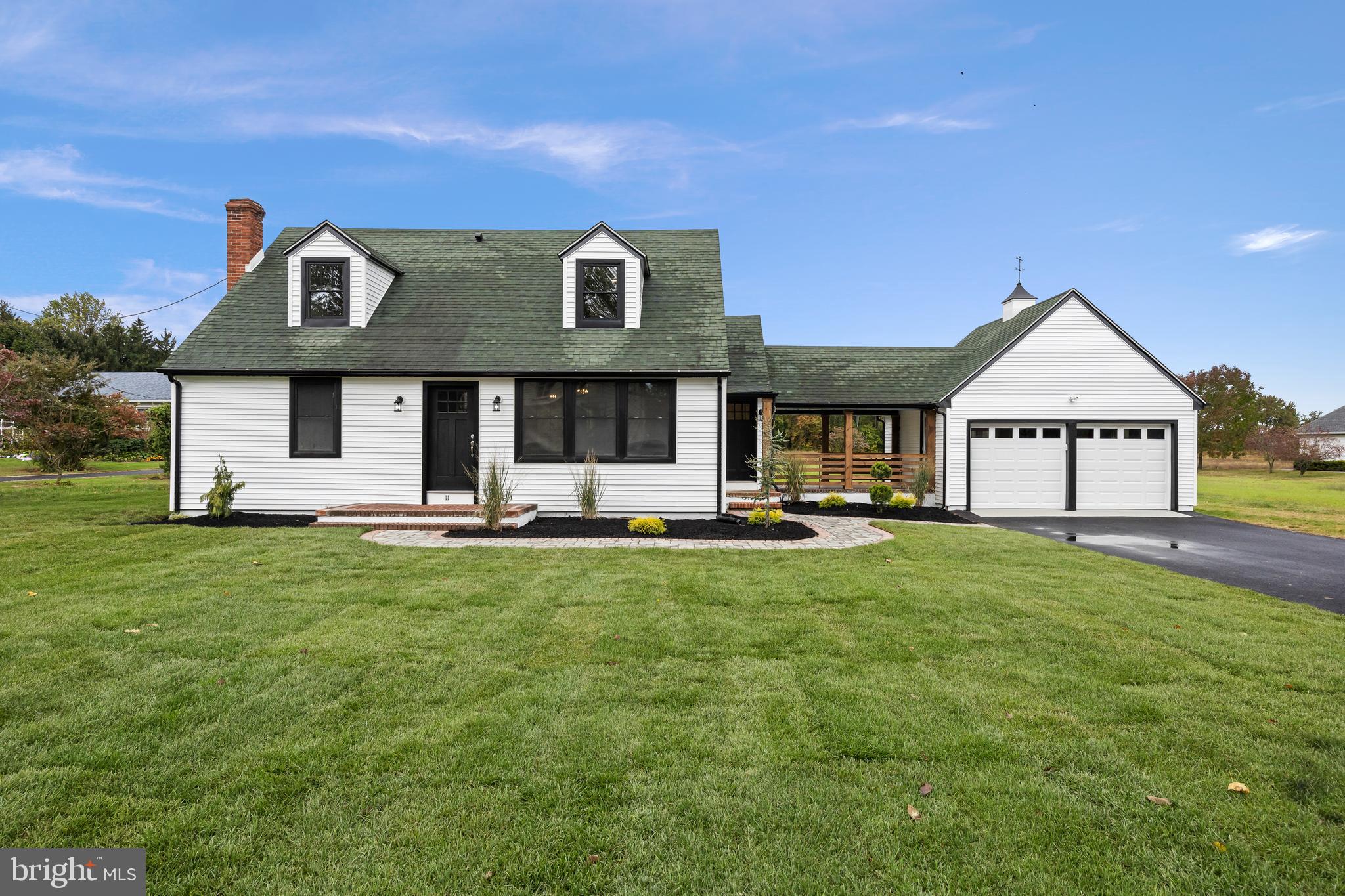 a front view of a house with yard and green space